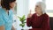 Senior patient speaking with caregiver woman