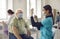 Senior patient waiting to get a shot and looking at young doctor getting the vaccine ready