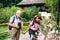 A senior pensioner couple with binoculars hiking, holding hands.