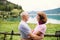 A senior pensioner couple hikers in love standing in nature, resting.