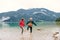 A senior pensioner couple hikers standing barefoot in lake in nature.