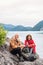 A senior pensioner couple hiking by lake in nature, sitting and resting.