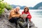 A senior pensioner couple hiking by lake in nature, using map.