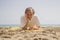 Senior pensioner sitting relaxed on the beach - retired old man on his 70s looking at the sea thoughtful and contemplative with