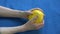 Senior pensioner woman hands doing rehabilitation exercises after stroke with yellow rubber ball