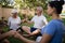 Senior people holding hands and meditating with trainer