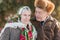 Senior people sits on the benck in the park. Happy elderly couple spend time outside in winter