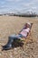 Senior person sitting in a deckchair on a beach