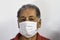 Senior Peruvian man suffers from cough with face mask protection, elderly man with facial mask due to air pollution
