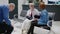 Senior physician consulting woman in waiting room lobby