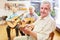 Senior practices playing guitar in a guitar class