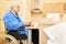 Senior reads newspaper in senior citizen apartment