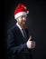 Senior red bearded Businessman winks in santa hat on black background