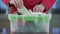 Senior repairman hands open green white plastic toolbox