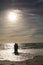 Senior retired multiracial couple enjoying waves together on shore at beach against sky