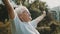 Senior retired woman enjoying freedom of retirement. Outstretched hands in the park, close up