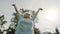 Senior retired woman enjoying freedom of retirement. Outstretched hands in the park, low angle shot