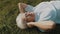 Senior retired woman with headphones lying on the grass and listening to the music