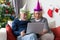 Senior retirement couple connect computer laptop  during Christmas celebration in their living room