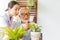 Senior retirement man and nurse are watering a small plant while relax at home