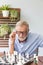 Senior retirement man playing chess with himself at home