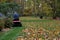 Senior on Riding Mower and Mulching Autumn Leaves