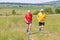 Senior runner running with his adult son on meadow