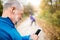 Senior runners in nature, stretching. Man with smartphone with e