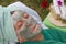 A senior\'s face is covered by clay facial mask.Close up