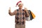 Senior with a santa claus hat showing a mobile phone and holding shopping bags