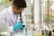 Senior scientist with formal uniform wearing safety goggle while watch microscope