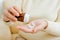 Senior sick woman holds medicine capsules from bottle in her hand, takes antibiotics, anesthetic pills close-up.