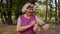 Senior sport runner woman using smart watch, tracking distance, checking pulse after fitness workout