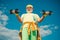 Senior sportman exercising with lifting dumbbell on blue sky background. Isolated, copy space. Senior man in gym working