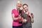 Senior sportswoman and girl holding trophy and medal on grey