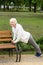 senior sportswoman in headphones doing push up near bench