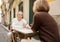 Senior Spouses Having Date Traveling Sitting At Table In Cafe