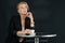 Senior successful business blond hair woman is taking a coffee before meeting in restaurant with partners in black background