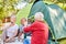 Senior takes photo of friends in front of the tent