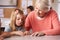 Senior teacher helping schoolgirl in elementary class