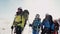 Senior of the team of climbers shows the direction of the path hand with an ice pick. the team listens to him