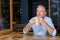 Senior thoughtful man holding cold coffee