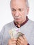 Senior thoughtful man holding dollar bills