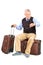 Senior tourist checking the time seated on his luggage