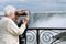 Senior tourist using binoculars at niagara falls