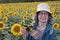 Senior tourist using vintage camera in sunflowers field