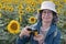 Senior tourist using vintage camera in sunflowers field