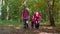 Senior tourists grandmother, grandfather, granddaughter kid talking, walking with backpacks in wood