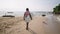 Senior traveler surfer holds surf board and walking at exotic beach on tropical island. Black old bearded man in