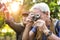 Senior trekker taking a photo with a film camera